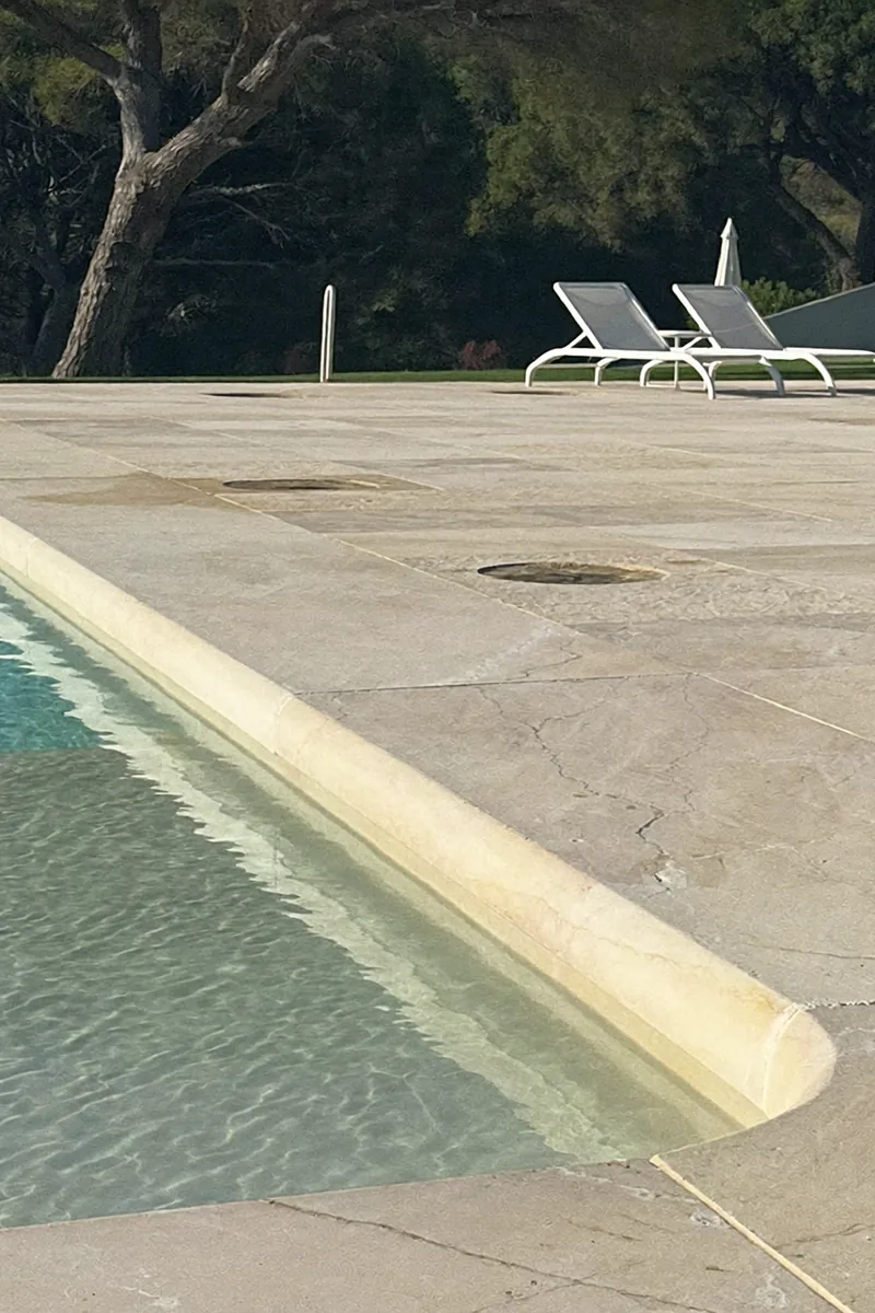 Illustration: Limestone pool deck next to a swimming pool with sun loungers